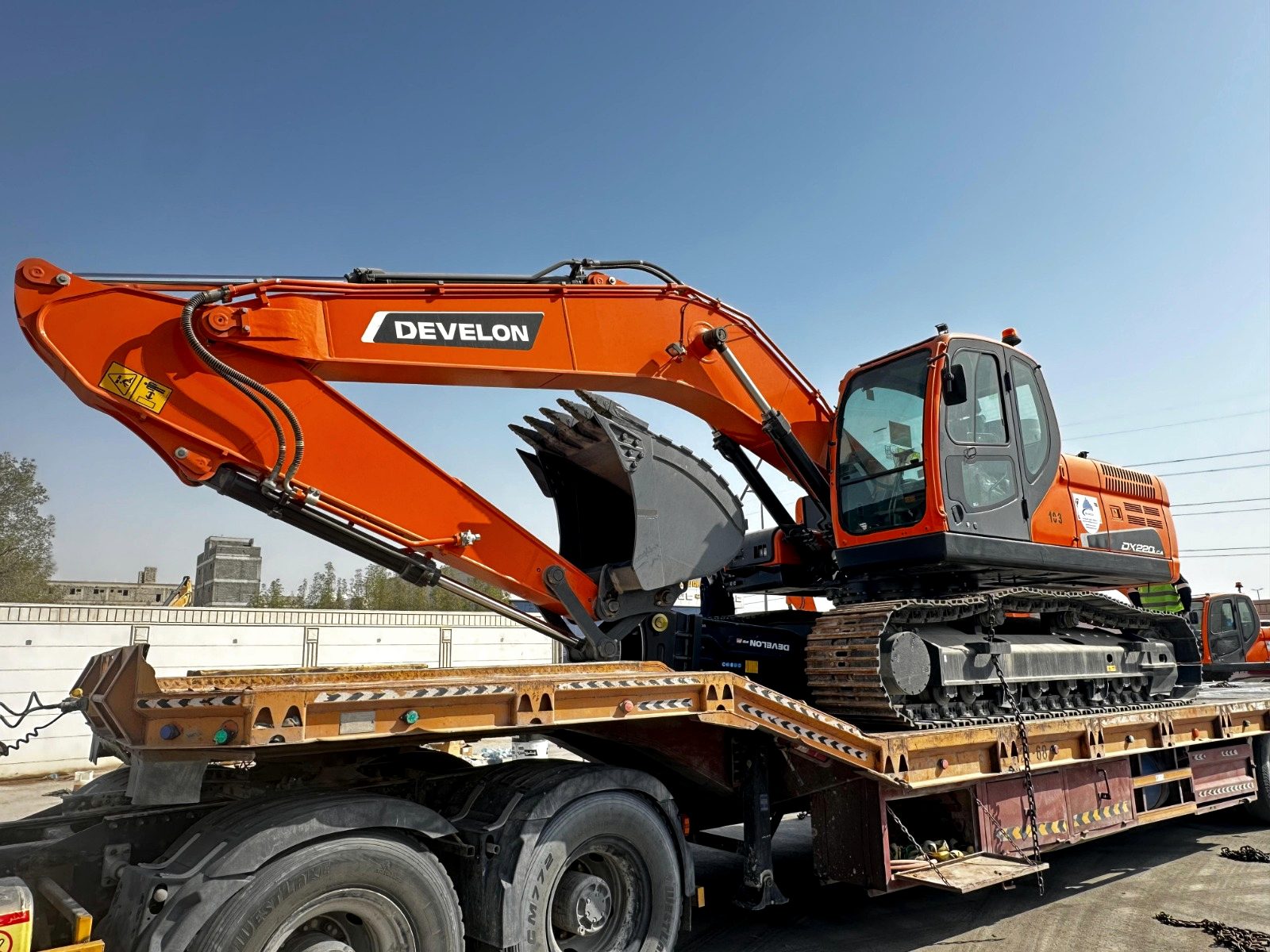 An excavator loaded onto a RANCO low-bed trailer